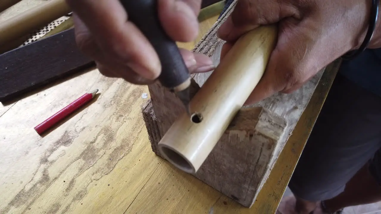 Hands of Flute Maker Artisan Works on Bamboo Musical Instrument Bali Indonesia Traditional Handicrafts