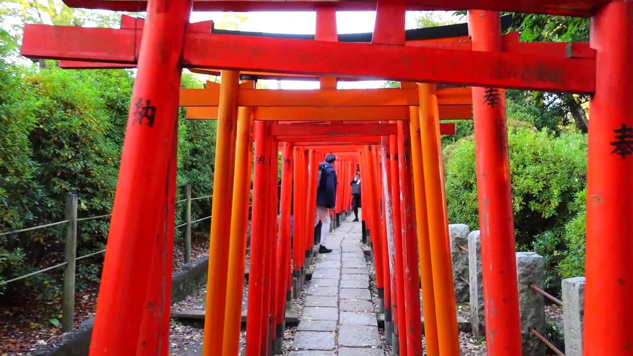 Walking through the red Torii Gate at Nezu Shrine park in Tokyo city Japan B-roll 4K