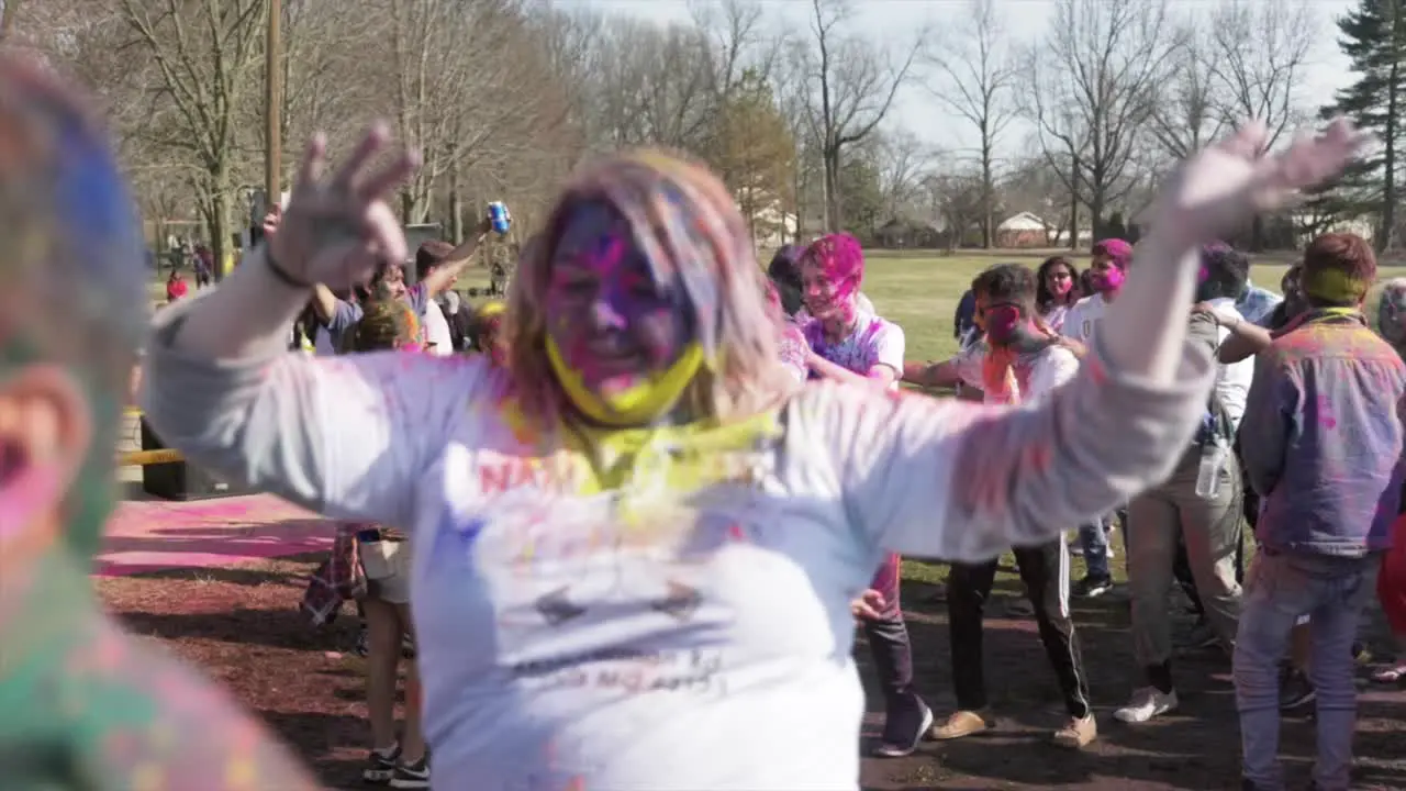 Happy people in circle dance during Holi festival Slow motion