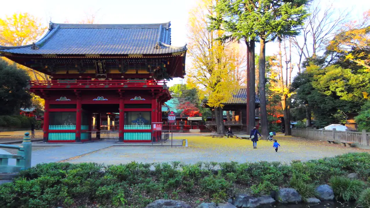 Nezu Shrine park with ancient Japanese style buildings in Tokyo city Japan 4K panning left