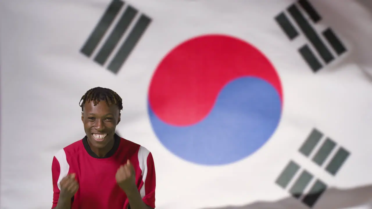 Young Footballer Celebrating to Camera In Front of South Korea Flag 01