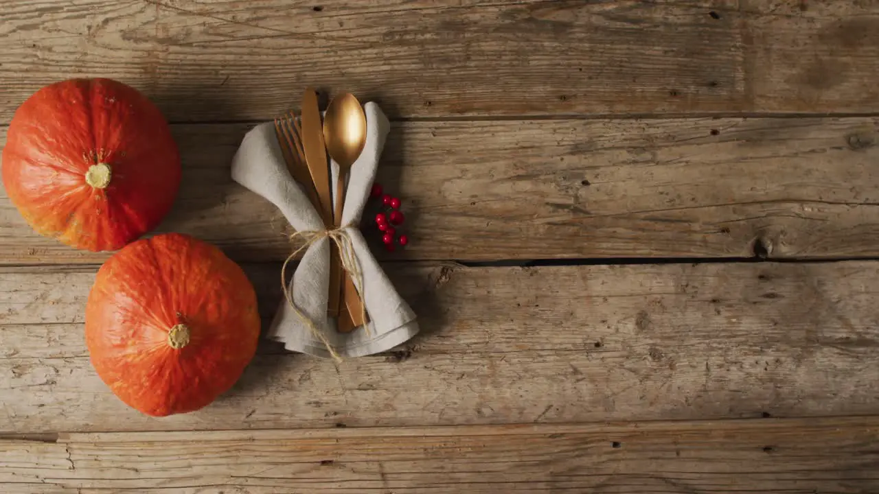 Video of cutlery and pumpkins lying on wooden surface