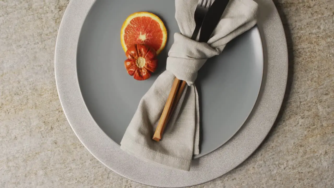 Video of plate with orange and autumn decoration lying on beige mat