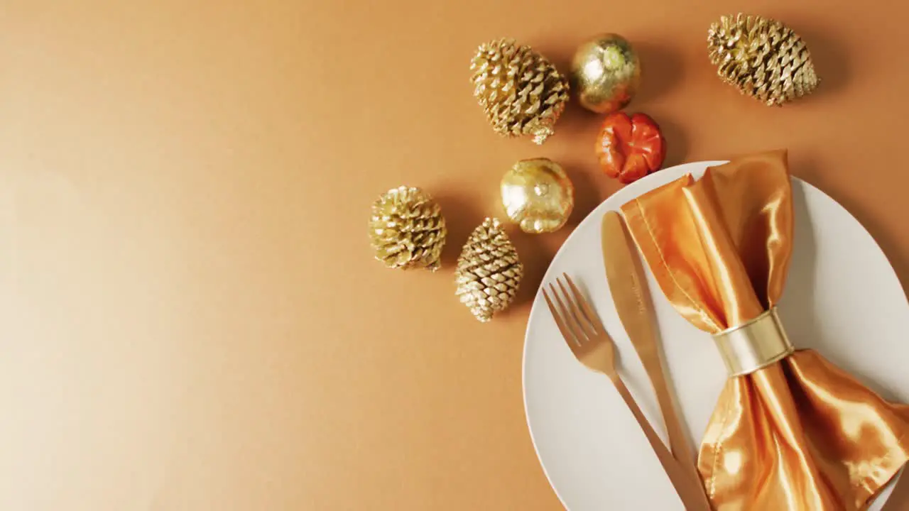 Video of plate with cutlery and autumn decoration with leaves on yellow surface