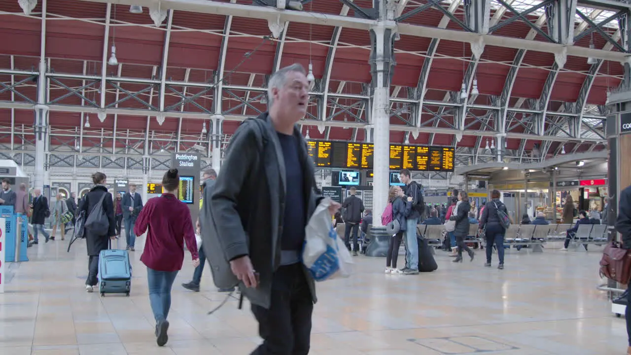 Commuters walk through busy Paddington Station in slow motion