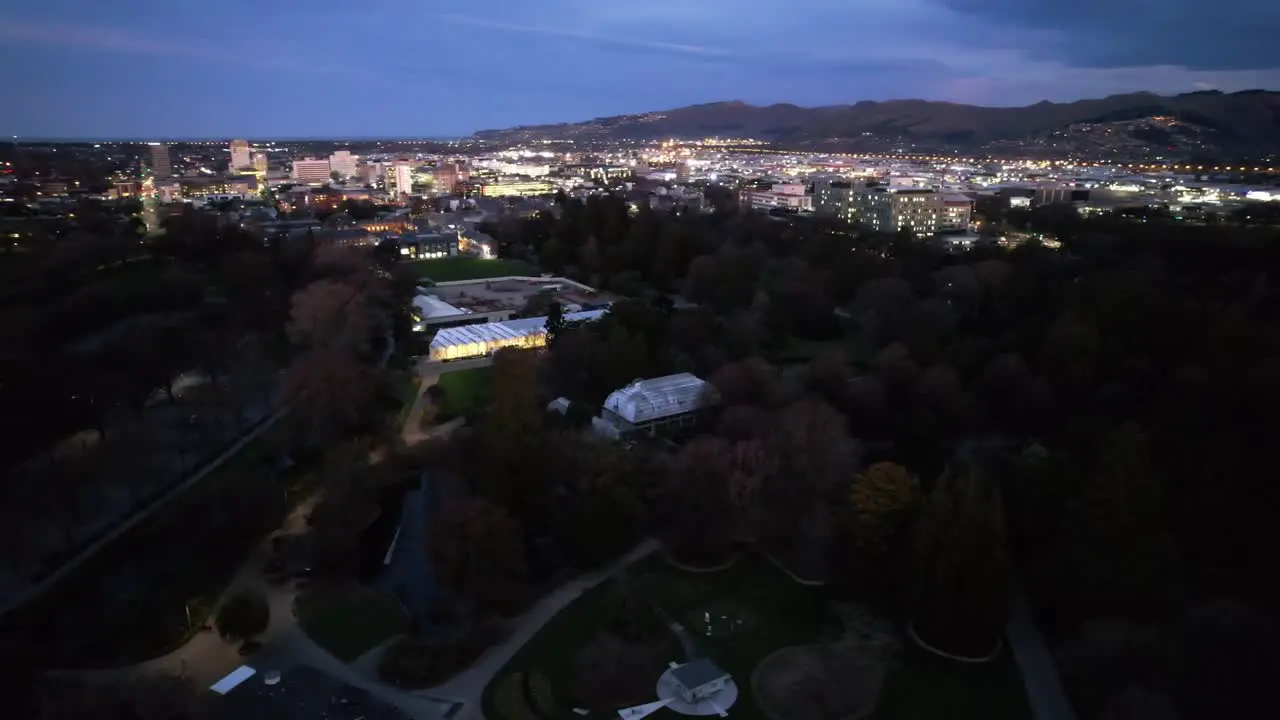 Christchurch gardens with city lights in the backdrop aerial orbit