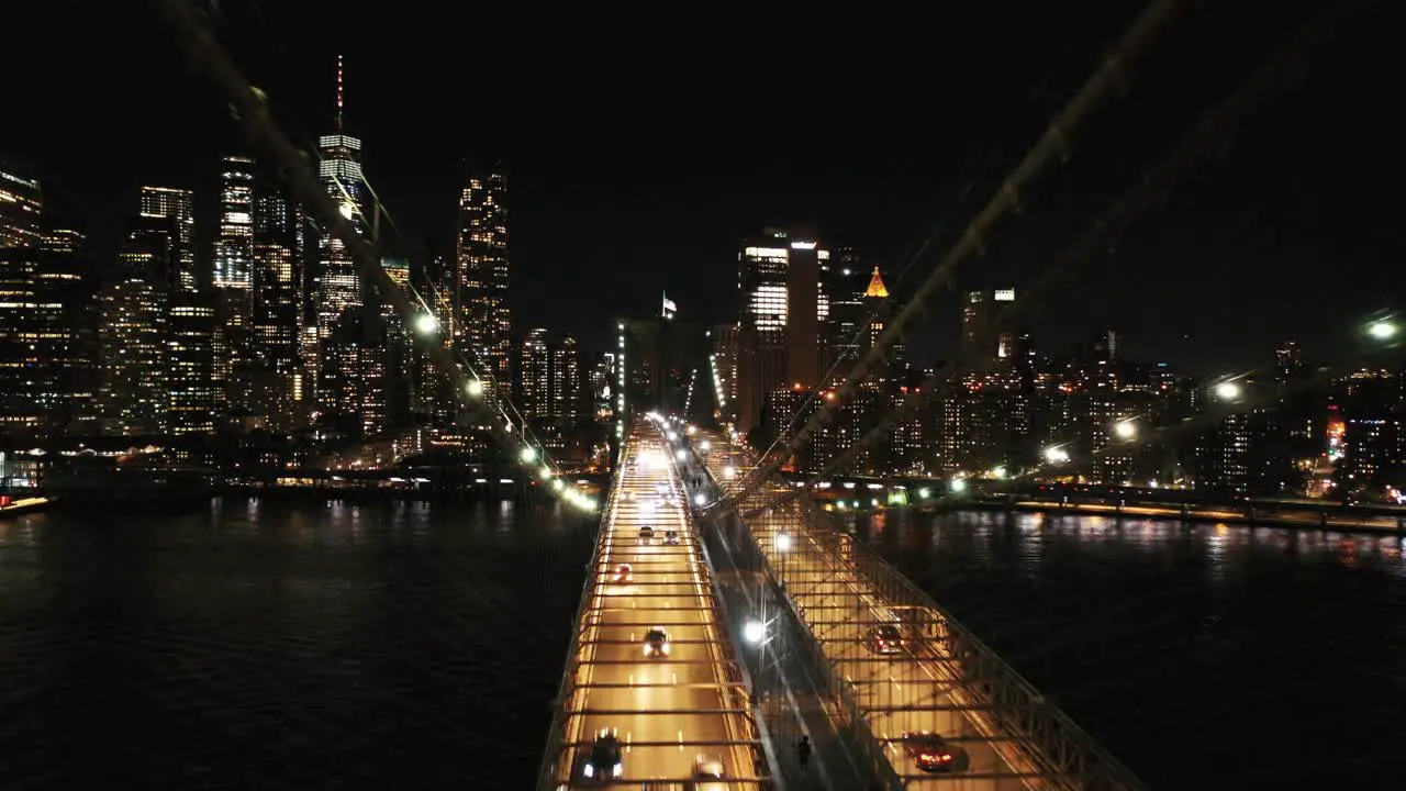 A slow drone shot of the NYC skyline from the Brooklyn Bridge at night