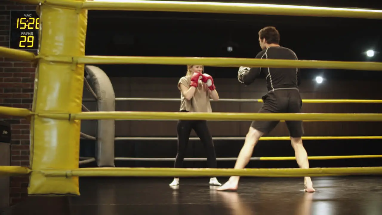 Young trainer teaching female boxer in sport club Sport woman training at gym