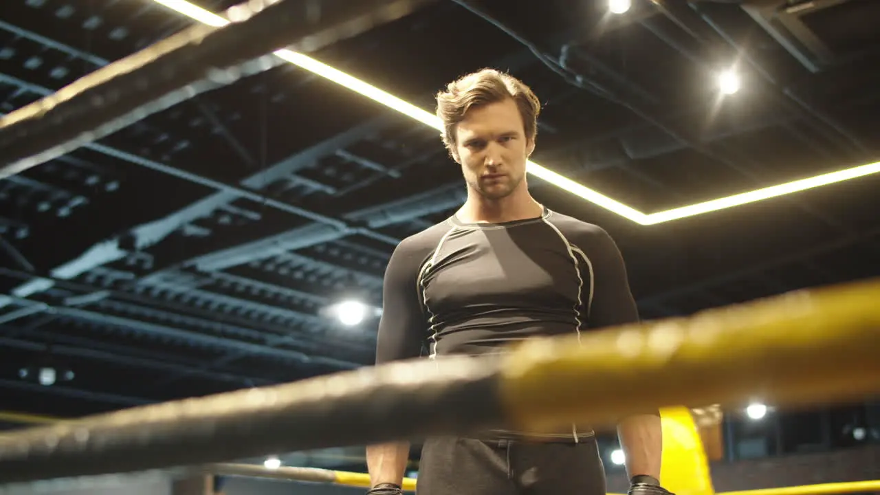 Annoyed fit man hitting fists on boxing ring Sport man getting ready for fight