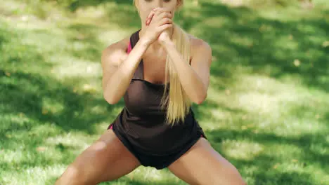 Sport woman doing squat exercise in city park at workout outdoor Fitness woman