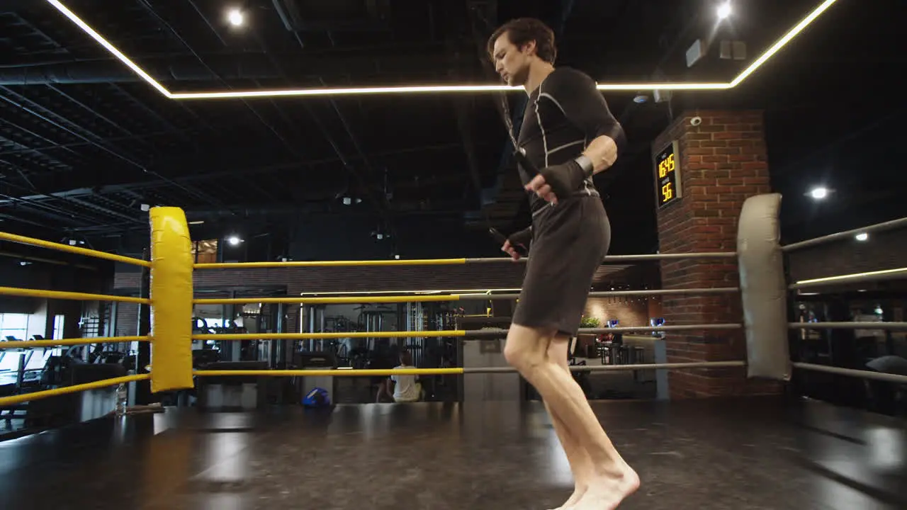 Energetic sport man making jumps at gym Male boxer exercising in sport club