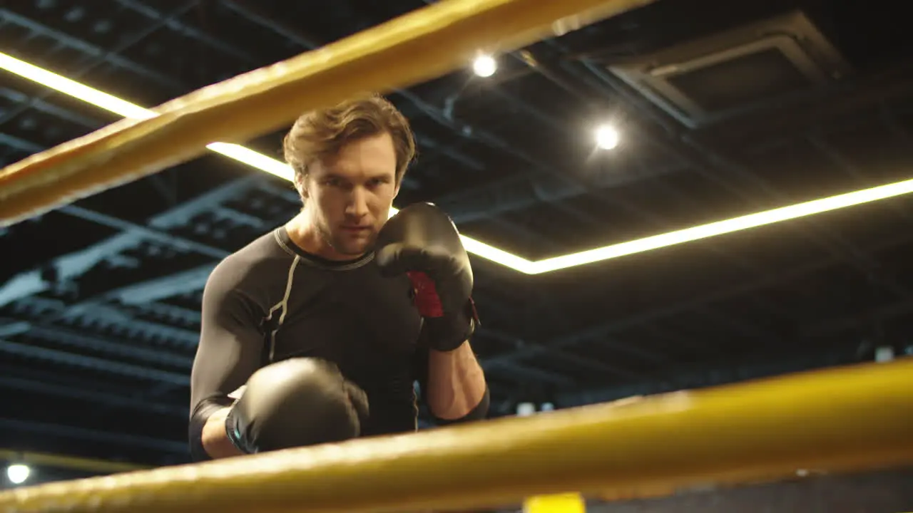 Focused sport man boxing at gym Male boxer doing punches on boxing ring