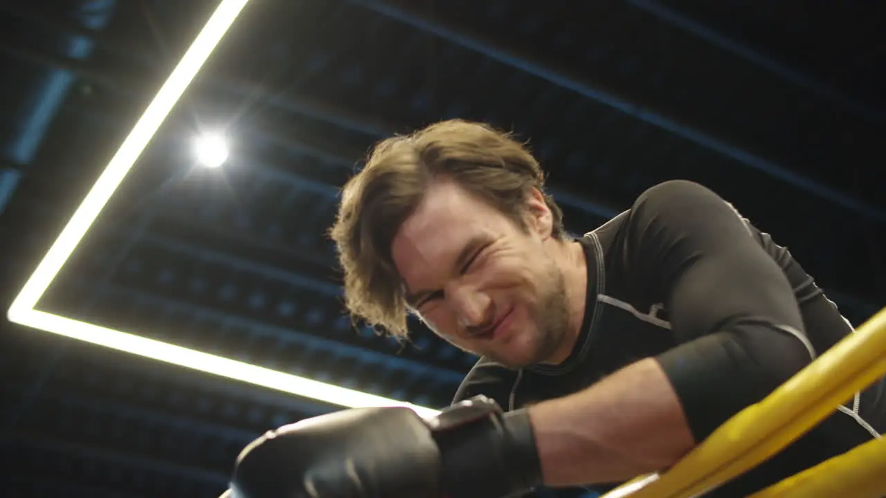 Aggressive male boxer screaming on boxing ring Sport man having a break at gym