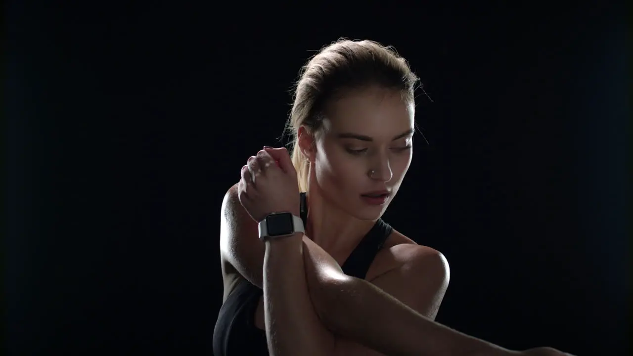 Sport woman doing stretch exercise on black background Fit girl warming up