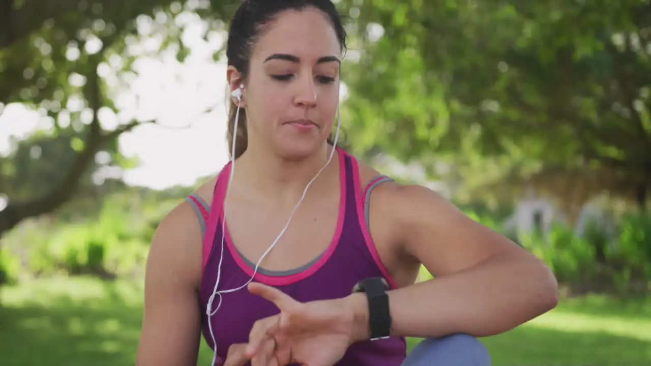 Woman looking at her watch in a park