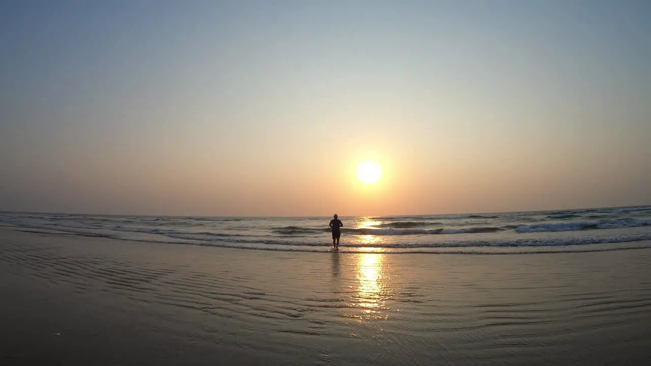 An Asian Indian Male Running into the Sunset on a Beautiful Beach during Summer Vacation