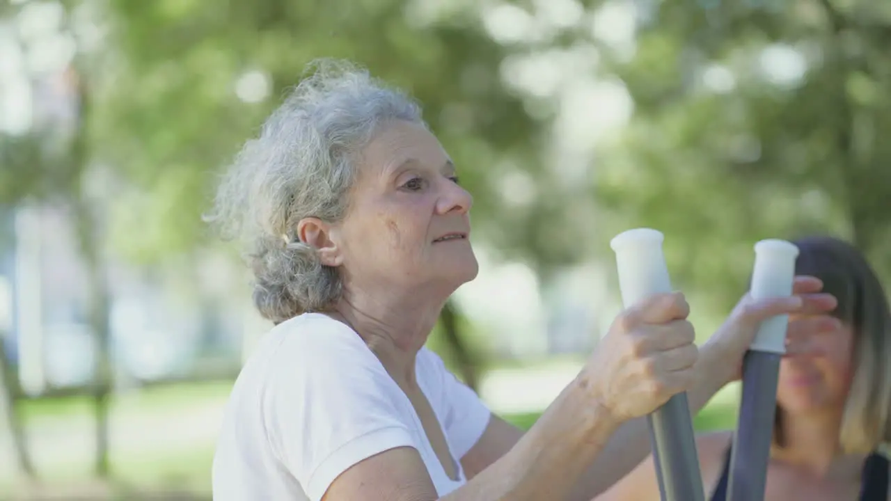 Smiling elderly woman training in summer park