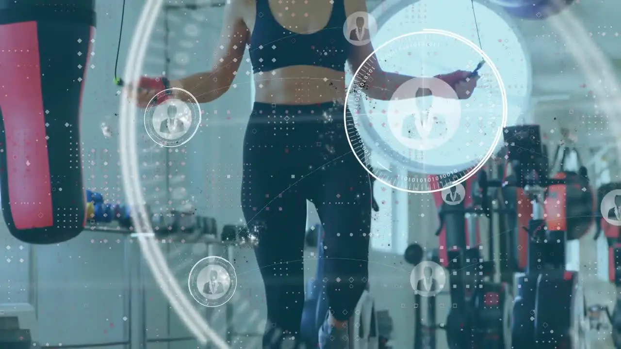 Animation of multiple profile icons over caucasian female boxer performing skipping exercise at gym