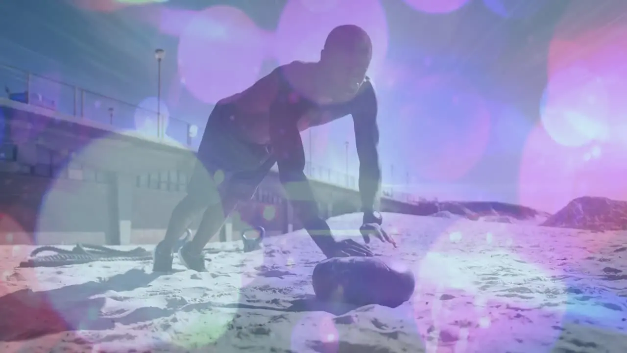 Purple spots of light against african american fit man performing push up exercise at the beach