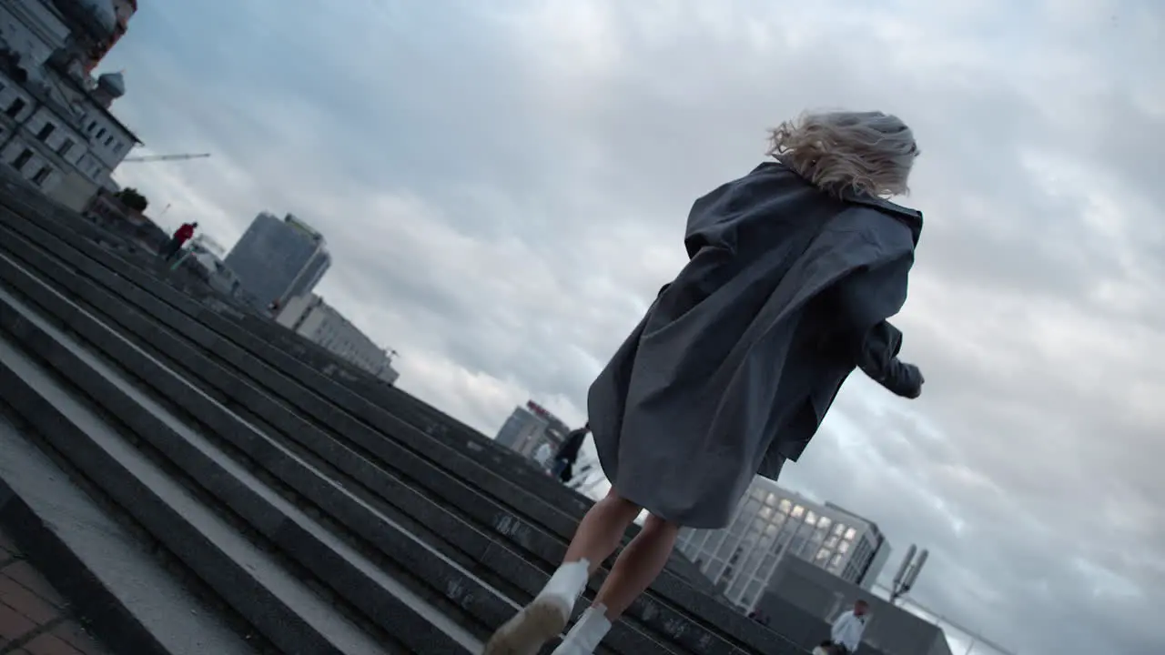 Lady walking up stairs in modern city view at urban background