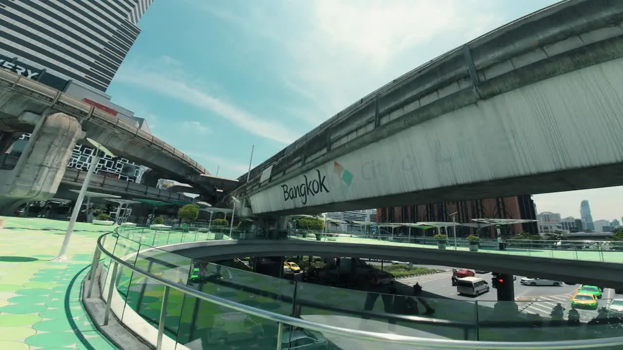 View of a bridge with 'Bangkok' written on it in the city with cars passing underneath