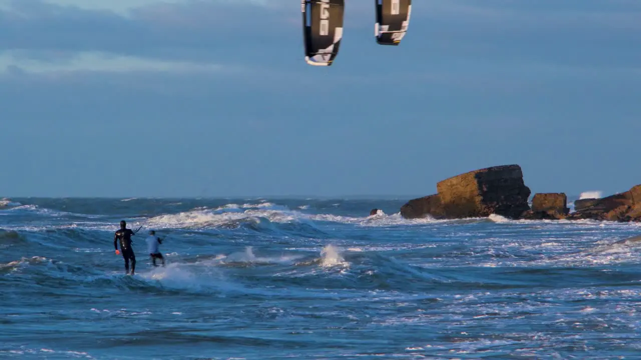 A group of people engaged in kitesurfing in sunny autumn day high waves Baltic Sea Karosta beach in Liepaja