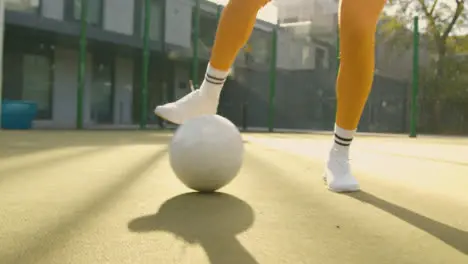 Close Up Of Female Football Player's Feet Practising Ball Control On Artificial Soccer Pitch In Urban City Area 