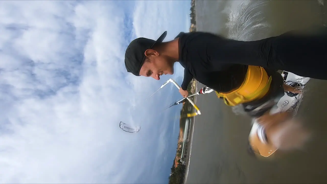 Caucasian man holding GoPro while kite surfing on ocean