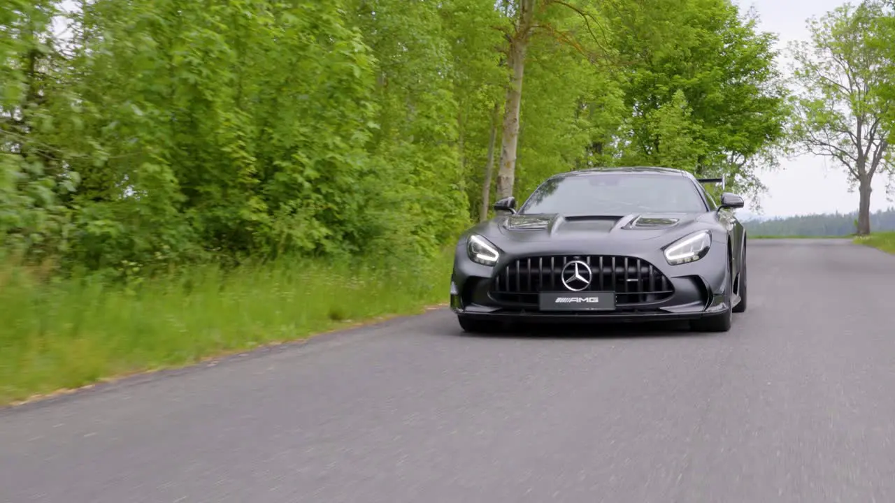 Beautiful black sports car driving slowly on a street dolly follow shot