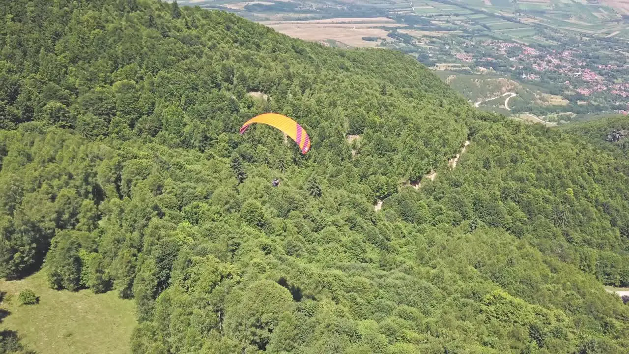 Paragliding over lush green mountain landscape