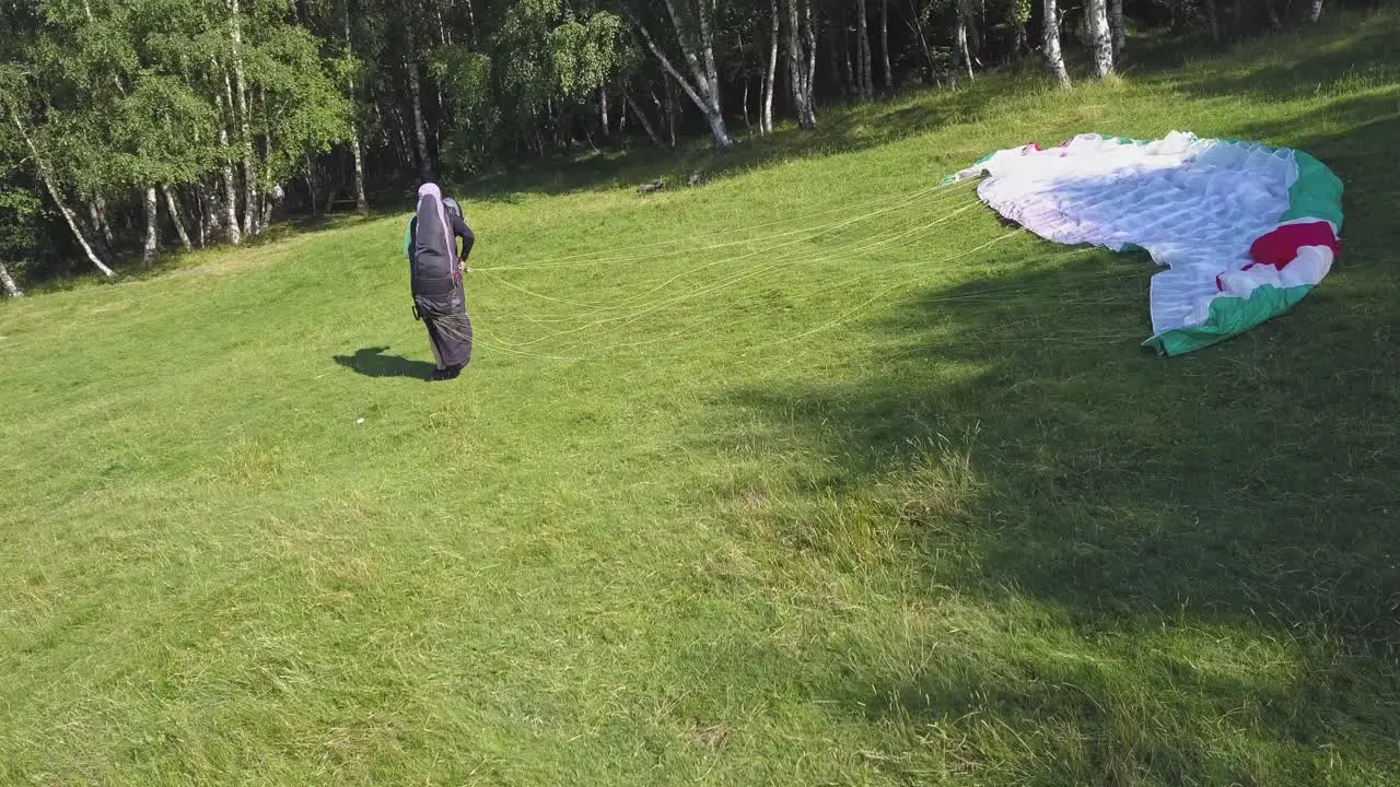 Paraglider untangles cord and getting ready to fly