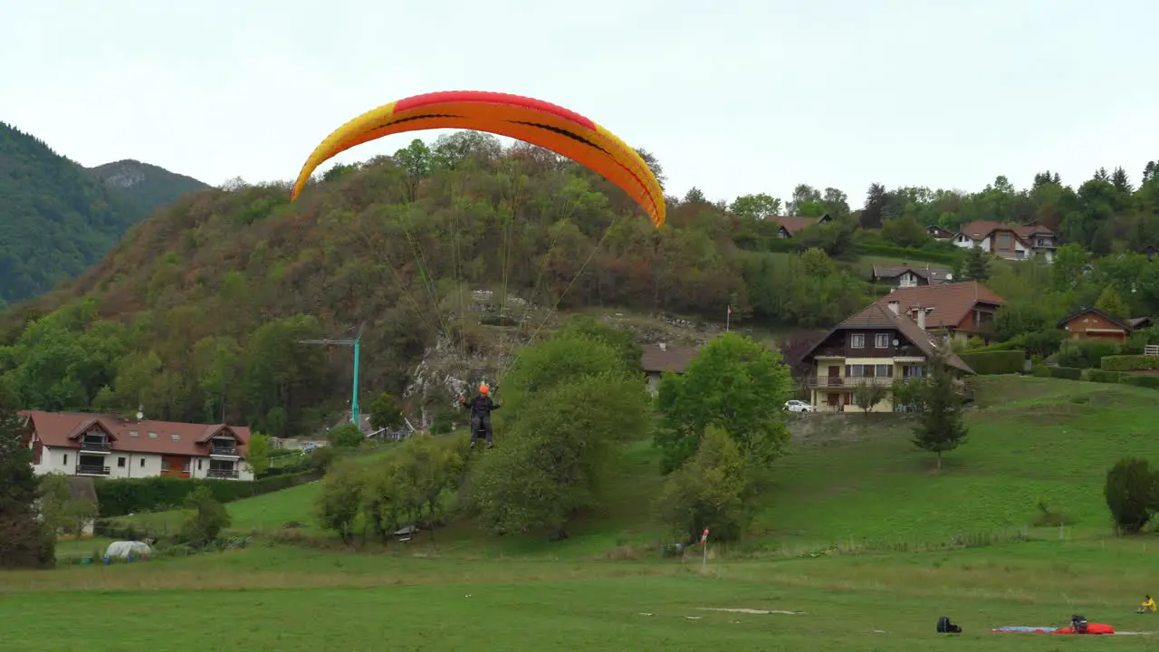 Paraglider Lands in the Field near the Lake Annecy