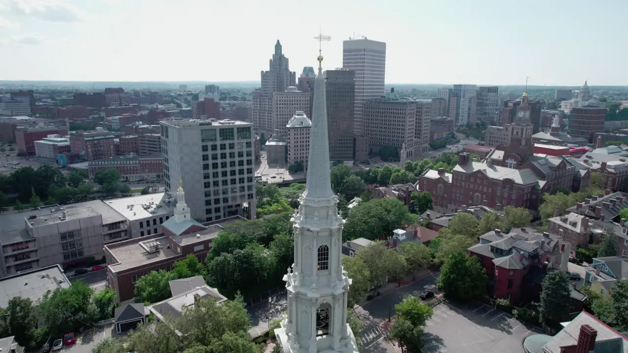 Aerial orbit of the spire of First Unitarian Church with the skyline of Providence RI in the background