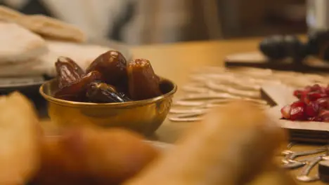 Close Up Of Bowl Of Dates On Muslim Family Table In Home Set For Meal Celebrating Eid