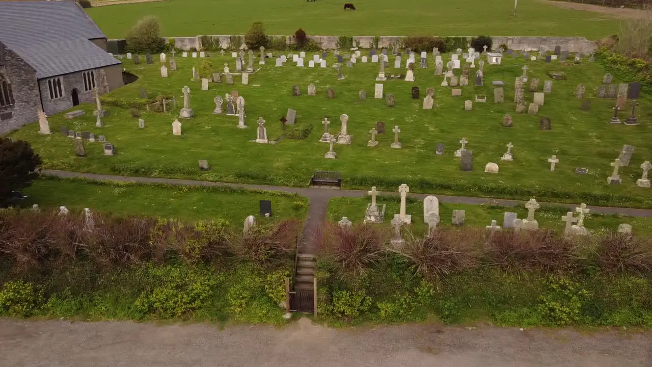 Aerial pan across Crantock churchyard Cemetery graveyard