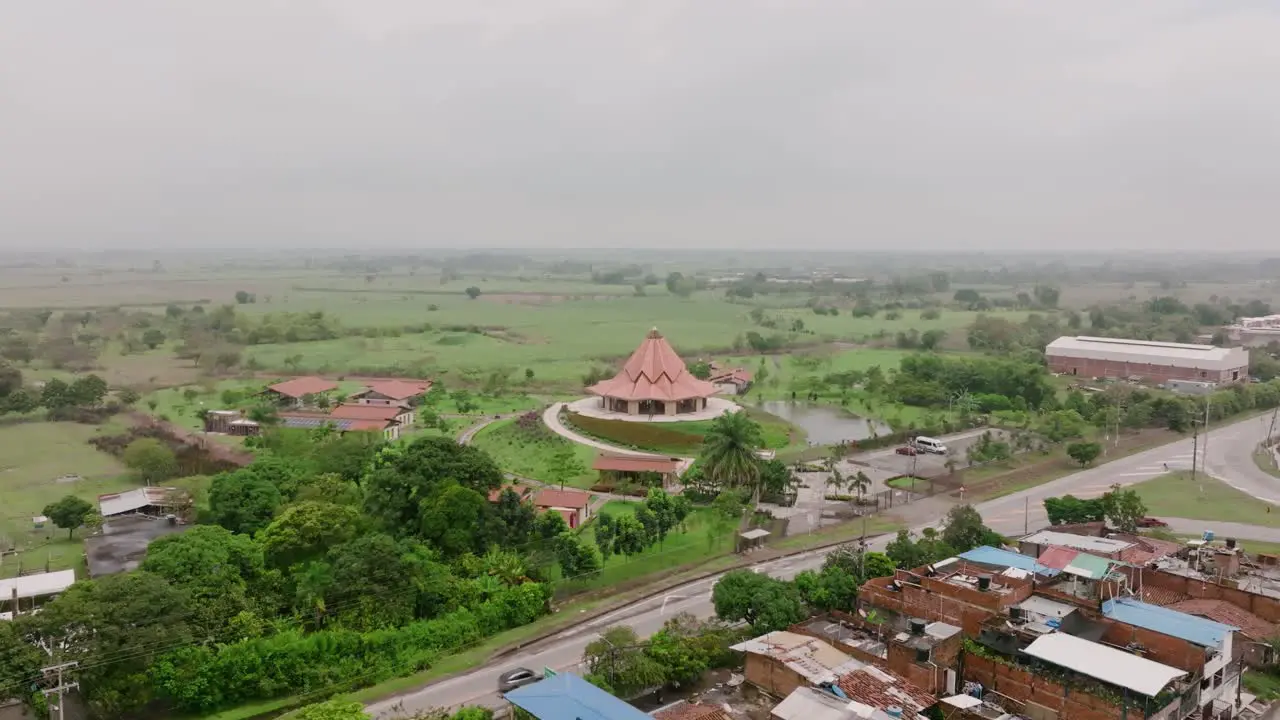 Aerial footage rising up showing a road and the Baha’i House of Worship in Cali Colombia