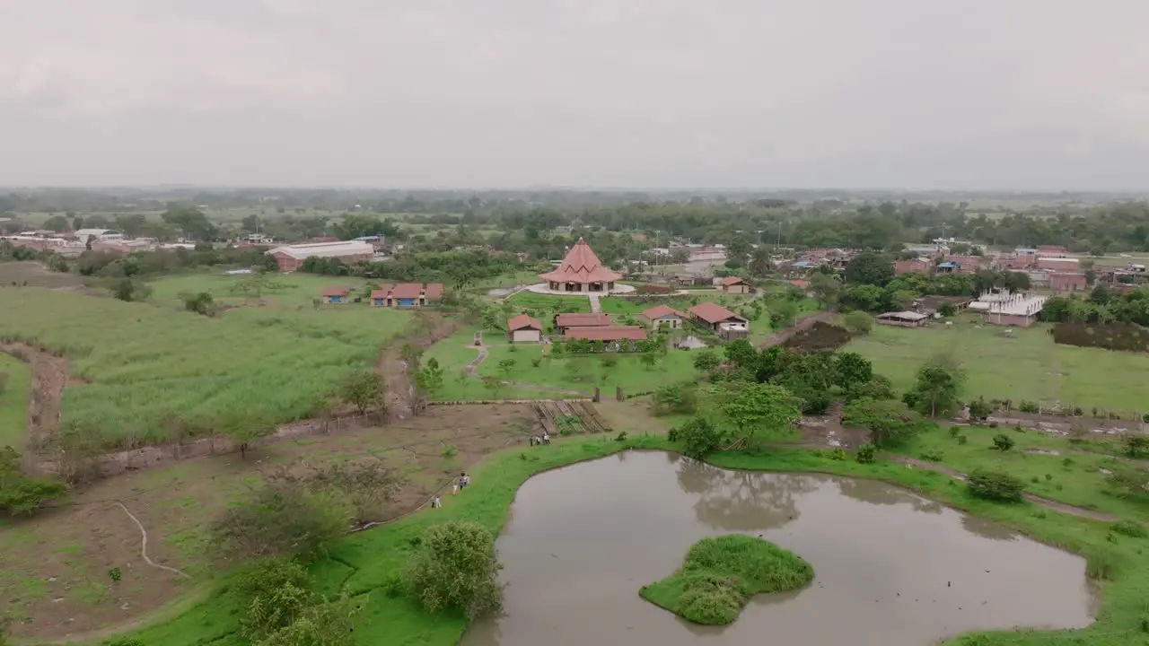 Aerial footage showing the pond birds flying a group of people walking and the Baha’i House of Worship in Cali Colombia