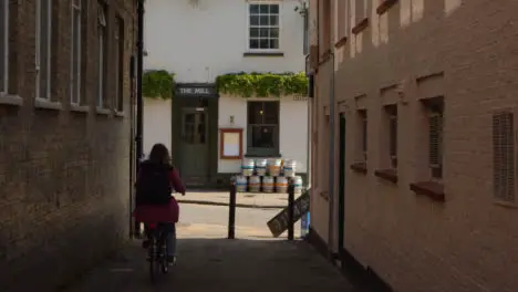 Tracking Shot of Cyclist Riding Through Quaint Alley