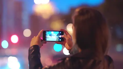 Video of city at night woman with smartphone