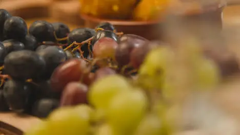 Close Up Of Red And Green Grapes On Muslim Family Table In Home Set For Meal Celebrating Eid