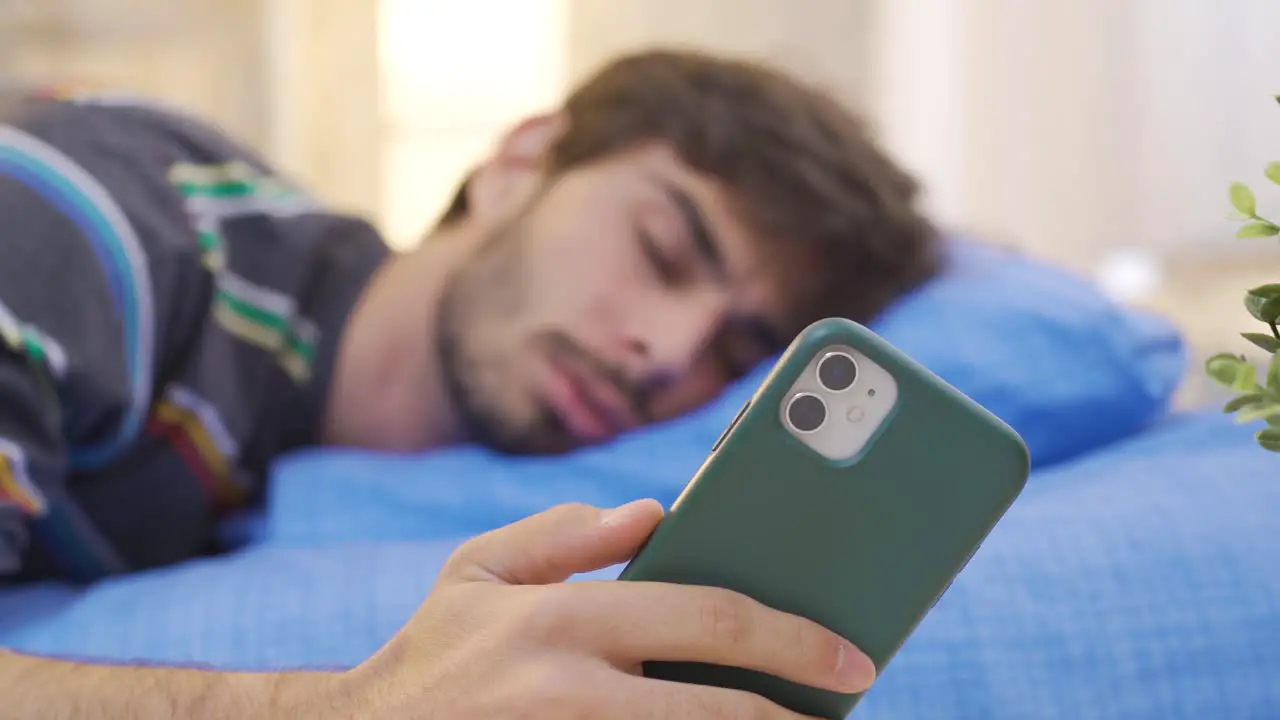 The napping young man does not let go of the phone