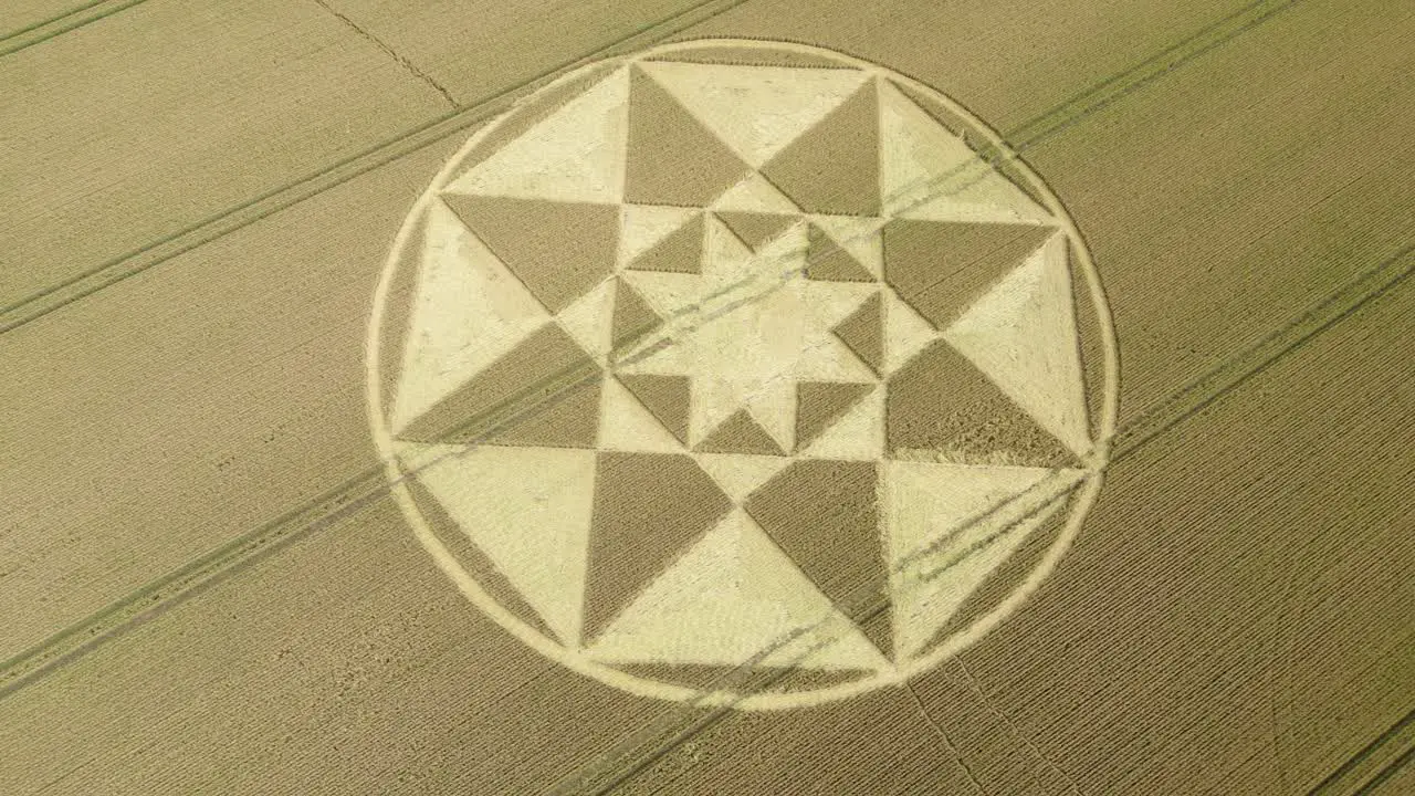 Star shaped crop circle pattern on golden Micheldever wheat field aerial view Slowly flying above 2023