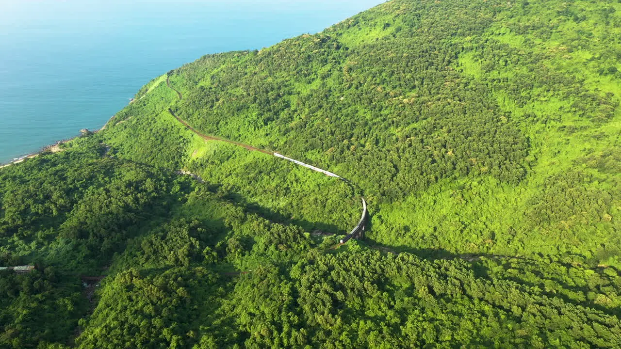 A train passes over a bridge in a scenic mountain pass in Danang Vietnam