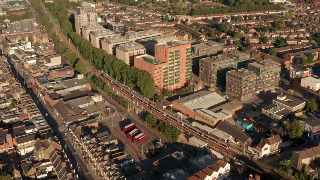 Rising aerial shot of London Overground train arriving at st James street station Walthamstow