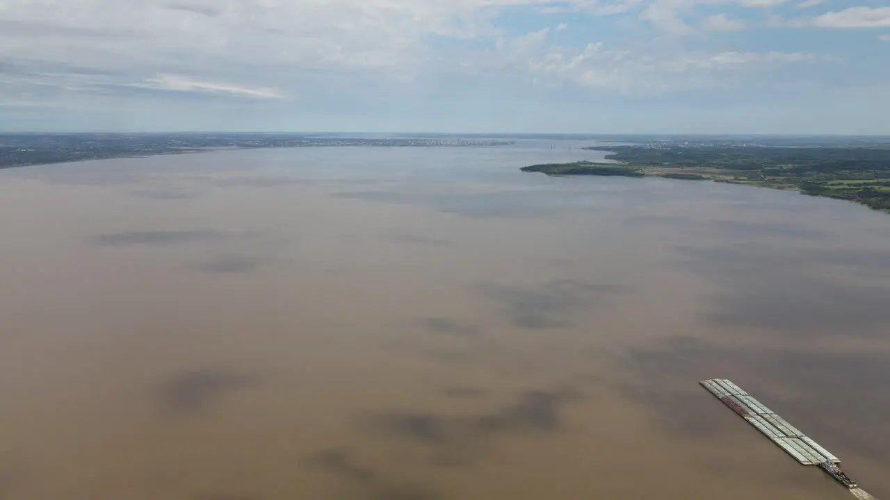 Aerial view of a transport boat navigating the vast Paraná River connecting Argentina and Paraguay showcasing the importance of river transportation for trade and commerce