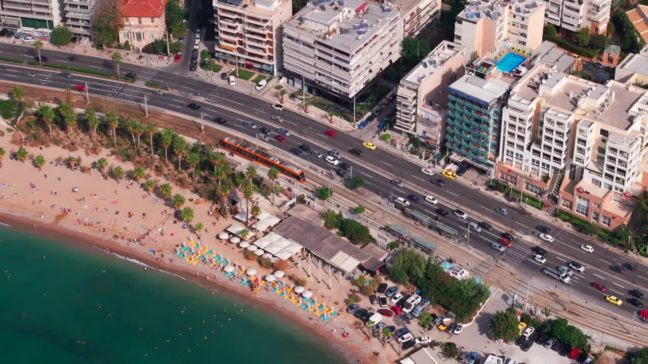 Aerial circling shot of a tram line and a road by the beach Athens Greece