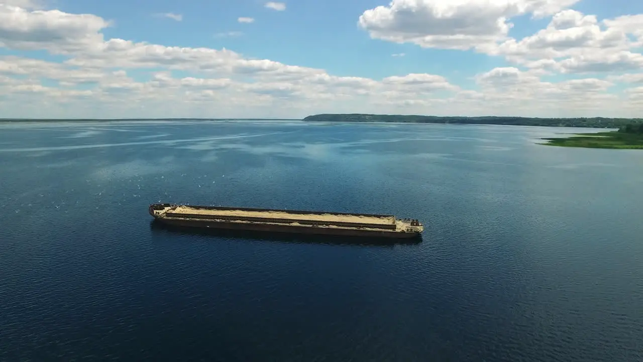 Rusty barge with sand on river Abandoned commercial cargo transportation