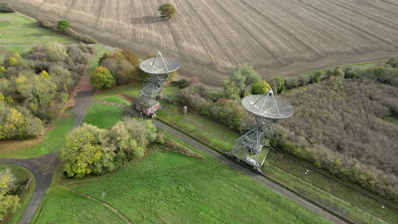 Aerial view orbiting Mullard MRAO radio observatory telescopes in Cambridge countryside