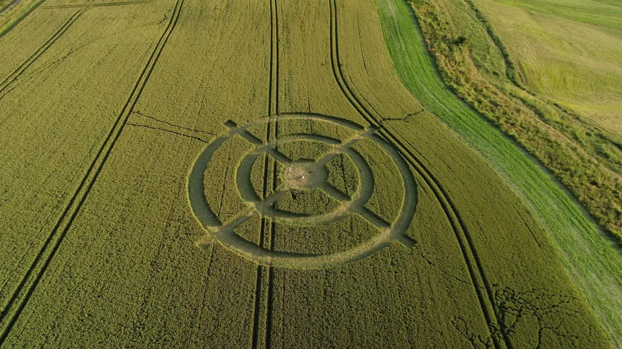 Hackpen hill strange crop circle symbols in rural grass farming meadow aerial view rising tilt down