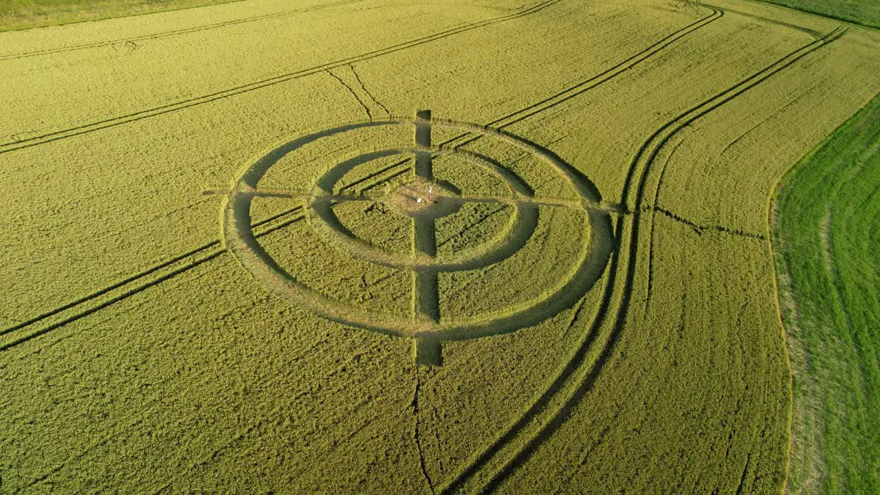 Hackpen hill strange wheat field target crop circle design in green farmland aerial view orbiting right